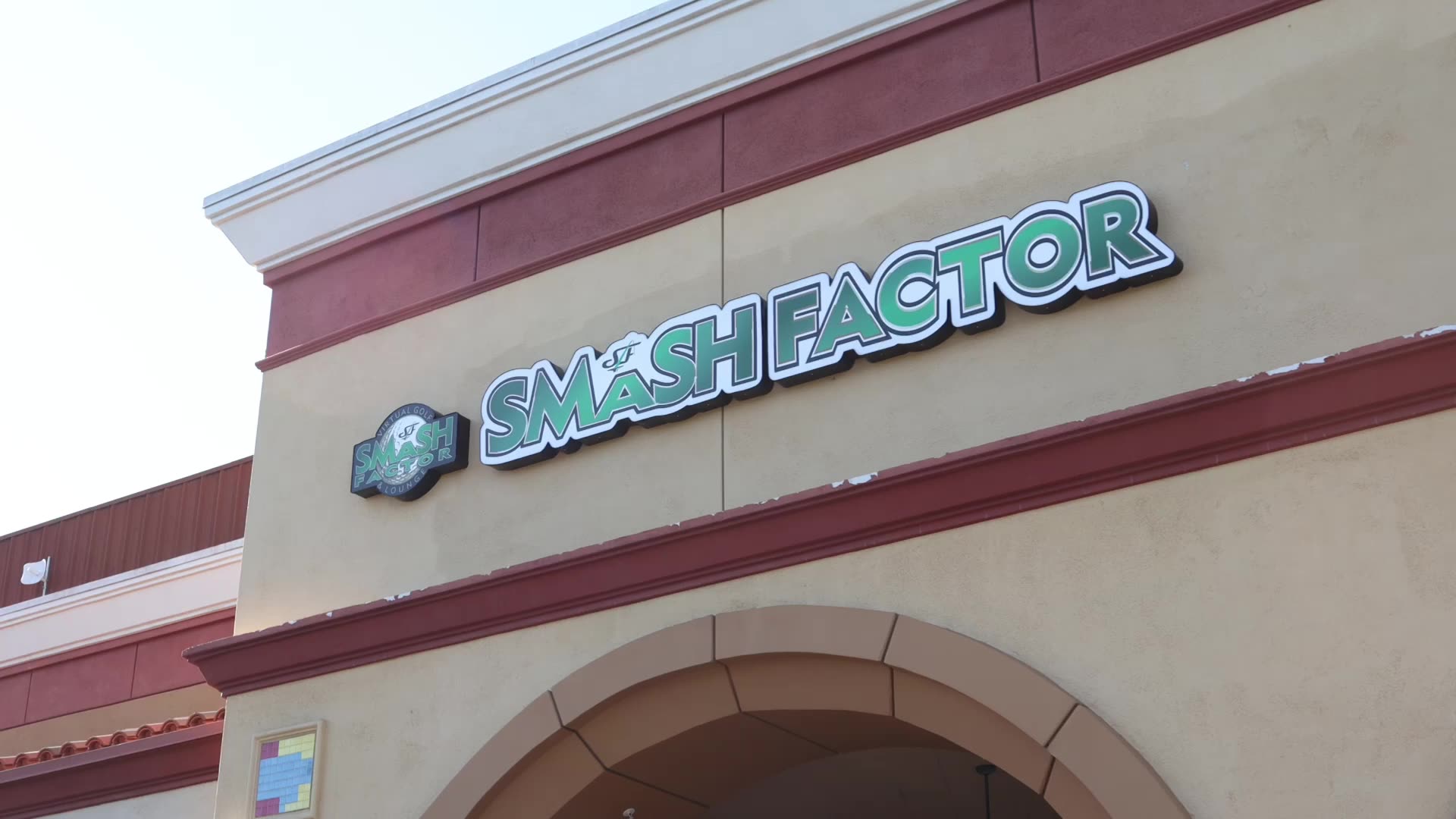 Smash Factor Virtual Golf: the sign outside, the bays with their Golfzon screens, the lounge, and a player lining up a shot.